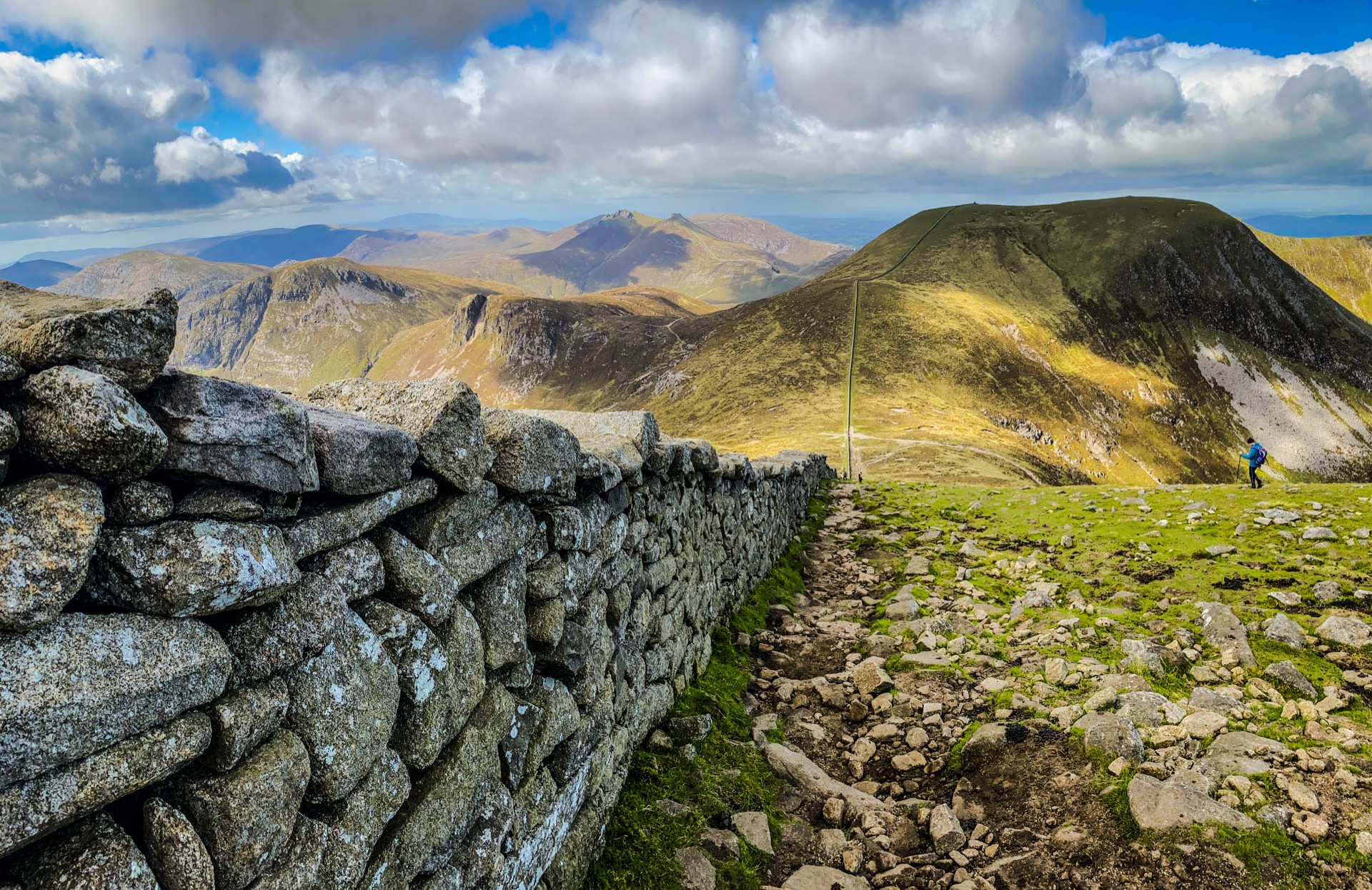 The Mourne Wall crossing a granite ridge, with mountain slopes and clouds beyond